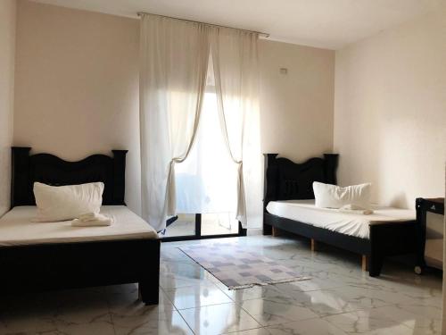 2 Betten in einem Zimmer mit Fenster in der Unterkunft Homeplace Sour in Tyros