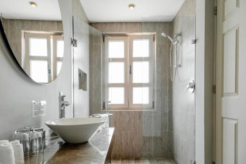 a bathroom with a white sink and a shower at Hotel Casa Once in Querétaro