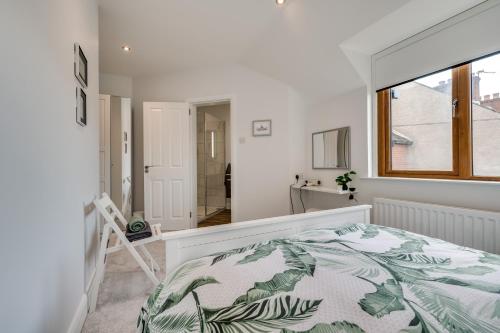 um quarto branco com uma cama e uma janela em Windsor Drive Townhouse em Belfast