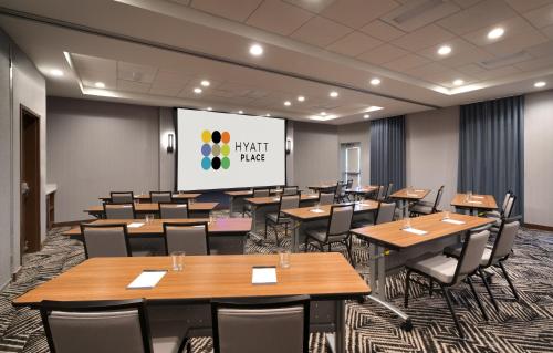 a conference room with tables and chairs and a projection screen at Hyatt Place Fayetteville/Springdale in Fayetteville