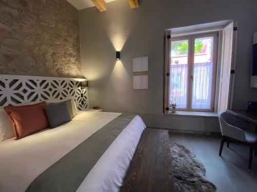 a bedroom with a bed and a window and a desk at Hotel Casa Once in Querétaro