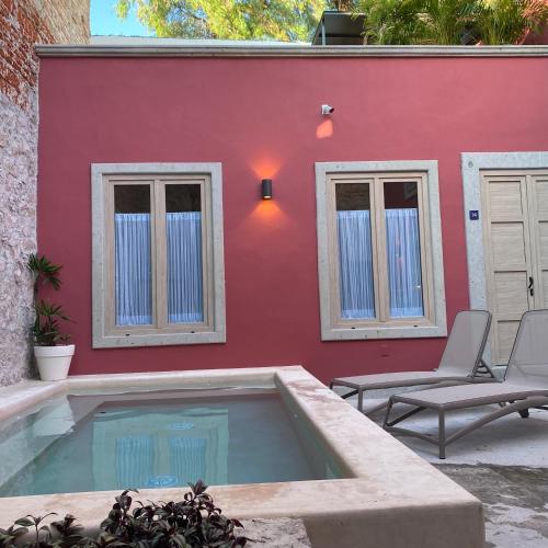 a red house with a swimming pool in front of it at Hotel Casa Once in Querétaro
