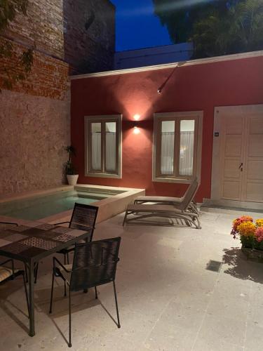 a patio with a pool and a table and chairs at Hotel Casa Once in Querétaro