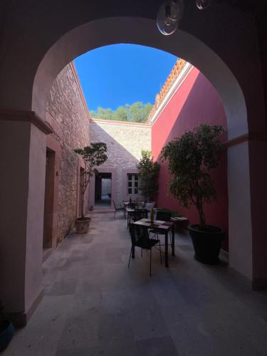 an archway with tables and chairs in a courtyard at Hotel Casa Once in Querétaro
