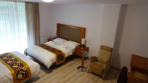 a hotel room with two beds and a chair at Lesní Lázně Muna in Hradec
