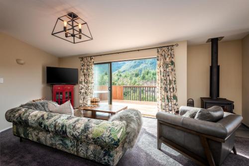 a living room with a couch and a fireplace at 'Love' Hanmer Couples Retreat Limited in Hanmer Springs