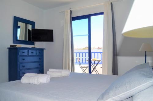 a bedroom with a bed with a television and a balcony at Casa Tacande in Yaiza