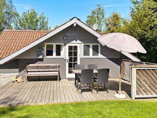 Casa con patio con mesa y sombrilla en 4 person holiday home in R dby, en Kramnitse