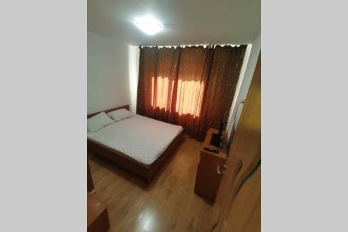 um pequeno quarto com uma cama e uma janela em Dana em Piteşti