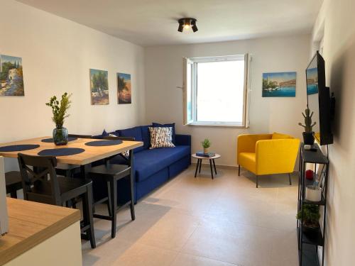 uma sala de estar com um sofá azul e uma mesa em Apartman Roko Duboka em Duboka
