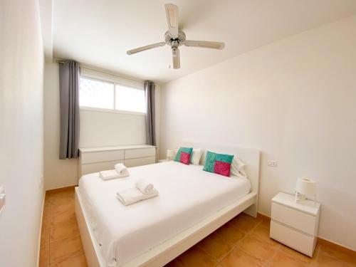 a bedroom with a white bed and a window at Rooftop Playa Paraiso FREE WIFI in Playa Paraiso