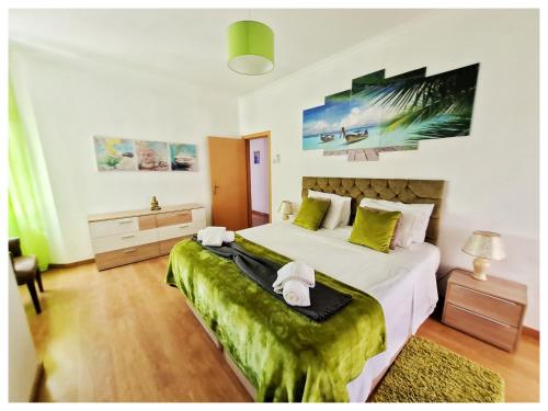 ポルティマンにあるLuxury 3 Bedroom Apartment - Portimãoのベッドルーム(緑のシーツを使用した大きな白いベッド付)