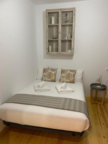 een slaapkamer met een bed met een spiegel erboven bij Oktheway Praza do Conde in Puentedeume