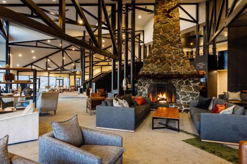 a living room with couches and a fireplace at Freycinet Lodge in Coles Bay