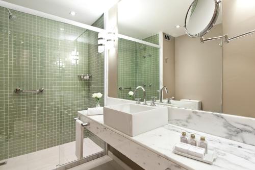 uma casa de banho com um lavatório e um espelho em eSuites Savassi Toscanini em Belo Horizonte