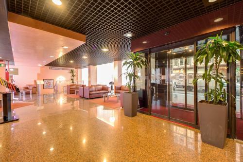 a lobby with potted plants in a building at Hotel Galileo in Milan