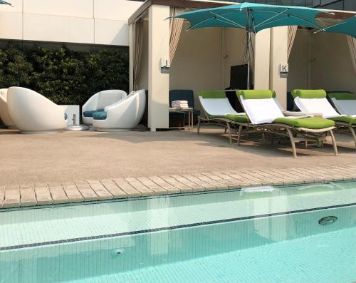 a swimming pool with chairs and umbrellas next to a building at Luxury Suites International at Vdara in Las Vegas