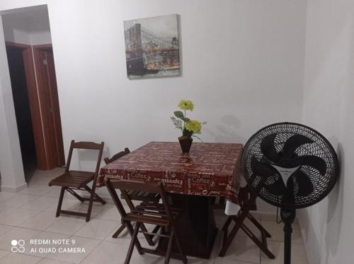 カンポス・ドス・ゴイタカゼスにあるLua E Agua Xのダイニングルームテーブル(椅子2脚、花瓶1台付)