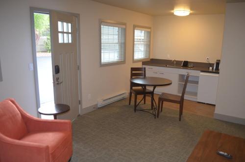 a living room with a table and chairs and a kitchen at Basalt Mountain Inn in Basalt