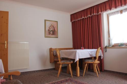 ペルティサウにあるWaldvilla am Seeのテーブル、椅子、窓が備わる客室です。