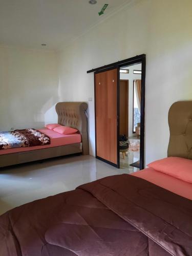a bedroom with two beds and a mirror at Villa Dhanty in Bogor