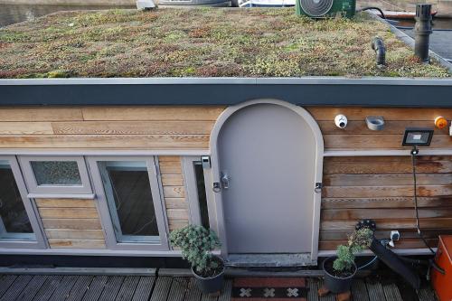 a house with an arched door and potted plants at HouseBoat next to AMSTEL in Amsterdam