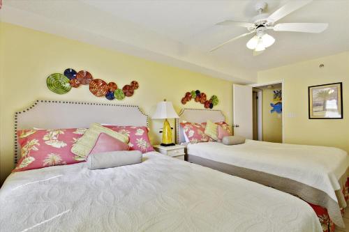 a bedroom with two beds and a ceiling fan at Phoenix 7 Unit 301 in Orange Beach