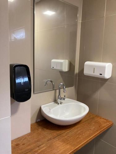 La salle de bains est pourvue d'un lavabo et d'un miroir. dans l'établissement Vila Verde casa com ar condicionado e vista da lagoa, à Florianópolis