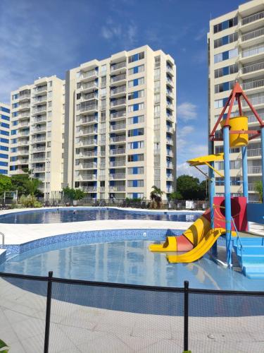 a pool with a slide in front of some buildings at INCREIBLE APARTAMENTO Puerto Azul Club House RICAURTE in Ricaurte