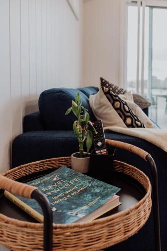 a wicker coffee table with a book and a plant at Wallinga Farmstay Mudgee in Mudgee