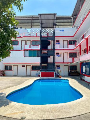 a swimming pool in front of a building at Hotel Maria Bonita Acapulco in Acapulco