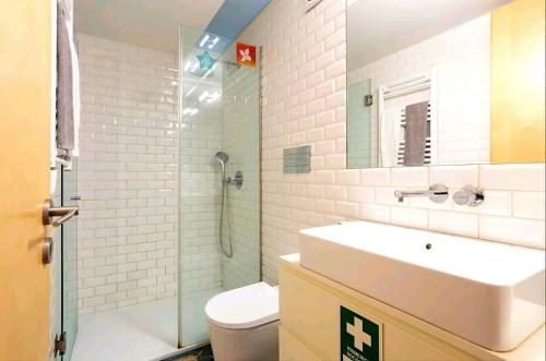 La salle de bains est pourvue d'une douche, d'un lavabo et de toilettes. dans l'établissement Oporto Blue Almada - Deluxe Citycenter Flat, à Porto