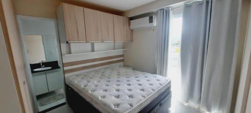 Habitación pequeña con cama y ventana en Apto Super confortável com Wifi en Guarapari