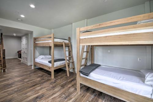two bunk beds in a room with wooden floors at Bross Brothers Cabin with Wraparound Porch! in Cottleville