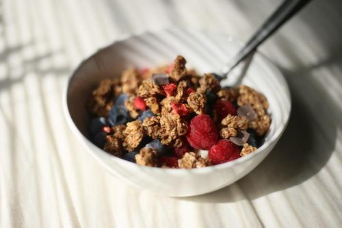 a bowl of cereal with berries and a spoon at Ocean Sands Beach Boutique Inn-1 Acre Private Beach-St Augustine Historic-2 Miles-Shuttle with Downtown Tour-HEATED Salt Water Pool until 420AM-Popcorn-Cookies-New 4k USD Black Beds- 69 Item Breakfast-Eggs-Bacon-Starbucks- Free Laundry- #904-799-SAND in Saint Augustine