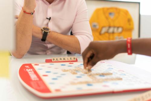 a woman is playing a board game on a table at Ocean Sands Beach Boutique Inn-1 Acre Private Beach-St Augustine Historic-2 Miles-Shuttle with Downtown Tour-HEATED Salt Water Pool until 420AM-Popcorn-Cookies-New 4k USD Black Beds- 69 Item Breakfast-Eggs-Bacon-Starbucks- Free Laundry- #904-799-SAND in Saint Augustine