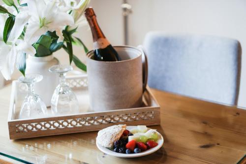 a table with a plate of food and a bottle of wine at Ocean Sands Beach Boutique Inn-1 Acre Private Beach-St Augustine Historic-2 Miles-Shuttle with Downtown Tour-HEATED Salt Water Pool until 420AM-Popcorn-Cookies-New 4k USD Black Beds- 69 Item Breakfast-Eggs-Bacon-Starbucks- Free Laundry- #904-799-SAND in Saint Augustine