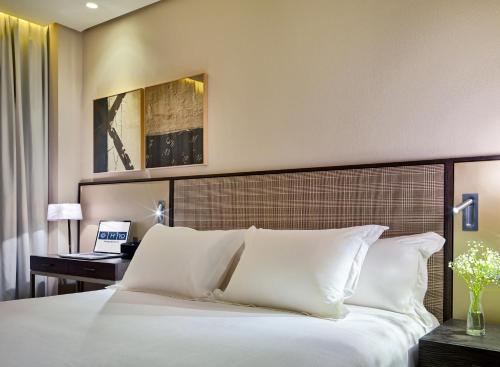 a bedroom with a large bed with white pillows at H10 Art Gallery 4* Sup in Barcelona