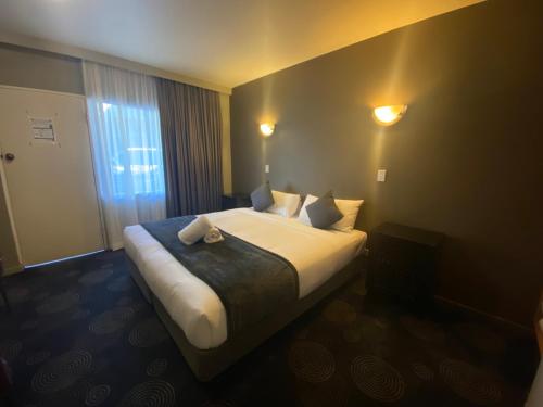 a hotel room with a bed and a window at The Astor Hotel Motel in Goulburn