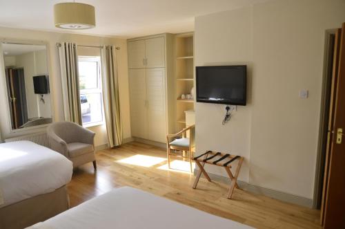 a hotel room with a bed and a tv on the wall at Seaview Guesthouse in Allihies