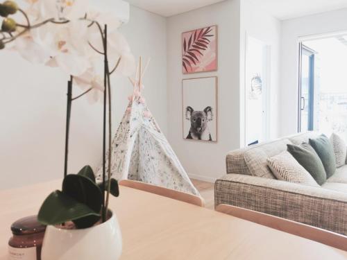 een woonkamer met een bank en een kerstboom bij Brand New Lux 2 Bedroom Apartment in Auckland
