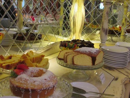 a table with a cake and other desserts on it at Pousada Italia Eleganza in Campos do Jordão