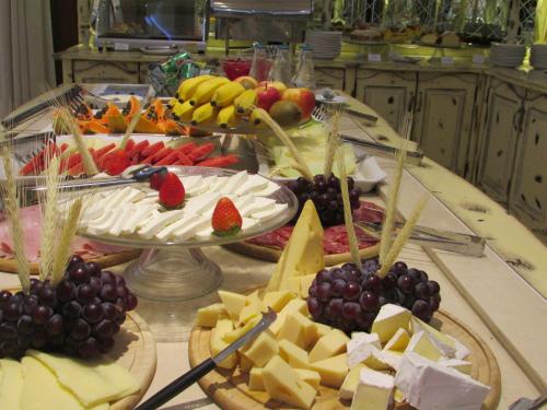 a buffet of cheese and fruit on a table at Pousada Italia Eleganza in Campos do Jordão