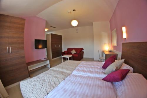 a bedroom with a large bed with pink walls at Villa Badi in Umag