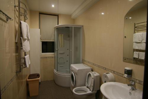 een badkamer met een douche, een toilet en een wastafel bij Aranda Hotel in Adler