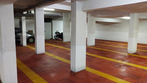 a parking garage with white columns and a motorcycle in it at Vivid A Boutique Hotel in Tiruchchirāppalli