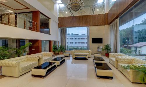 a large living room with couches and a tv at Treebo Premium Pearl Avenue Banquets And Lawn in Dehradun
