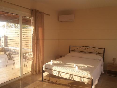 a bedroom with a bed and a balcony at Nereids Apartments-Erato in Petalidhion