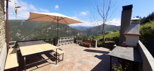 a patio with a table and an umbrella at Mirador del Navia in Serandinas