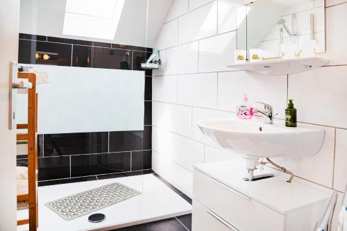 a white bathroom with a sink and a shower at Haus Christina in Seeboden